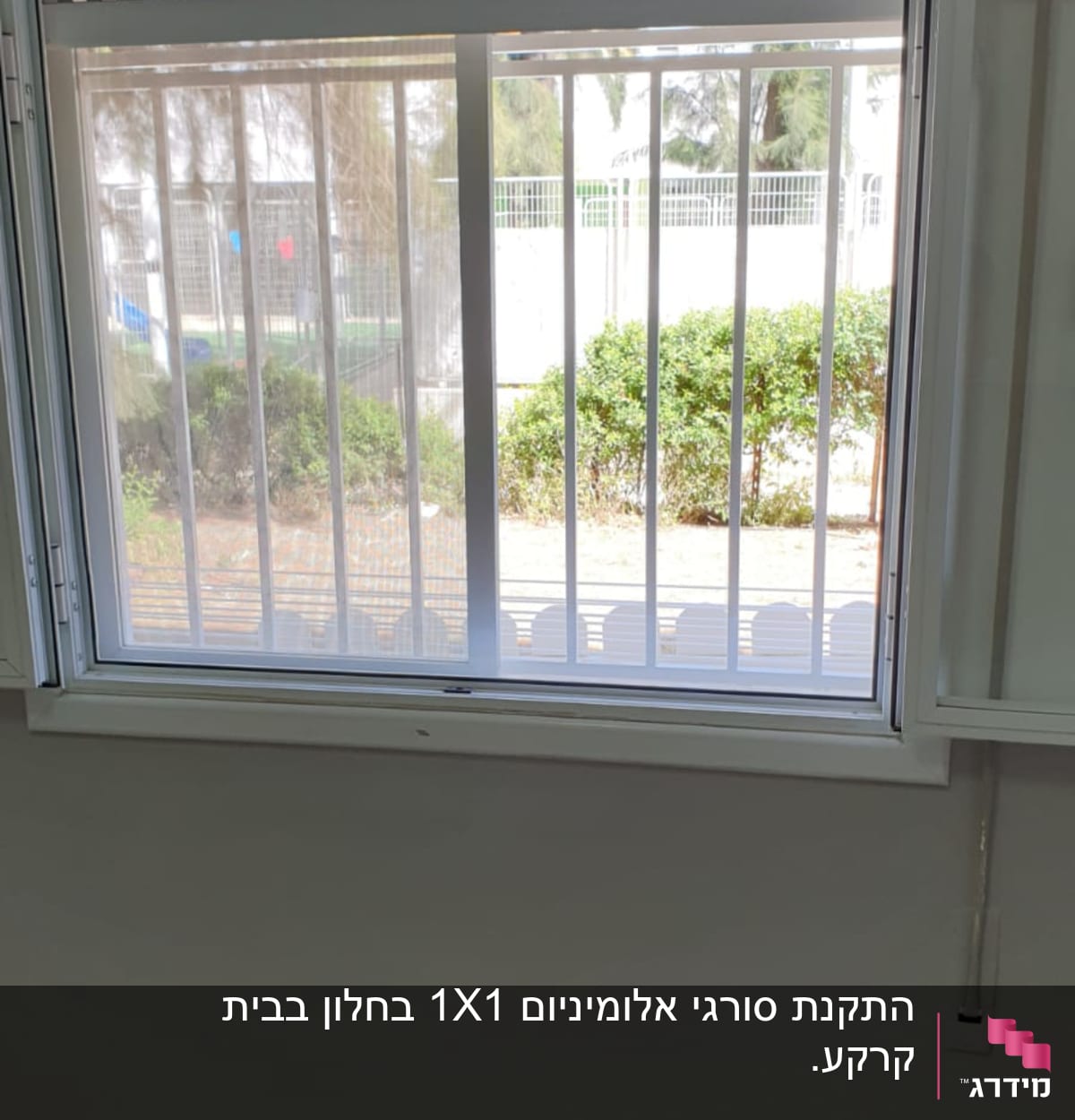 חלון עם מסגרת לבנה וסורגים אנכיים